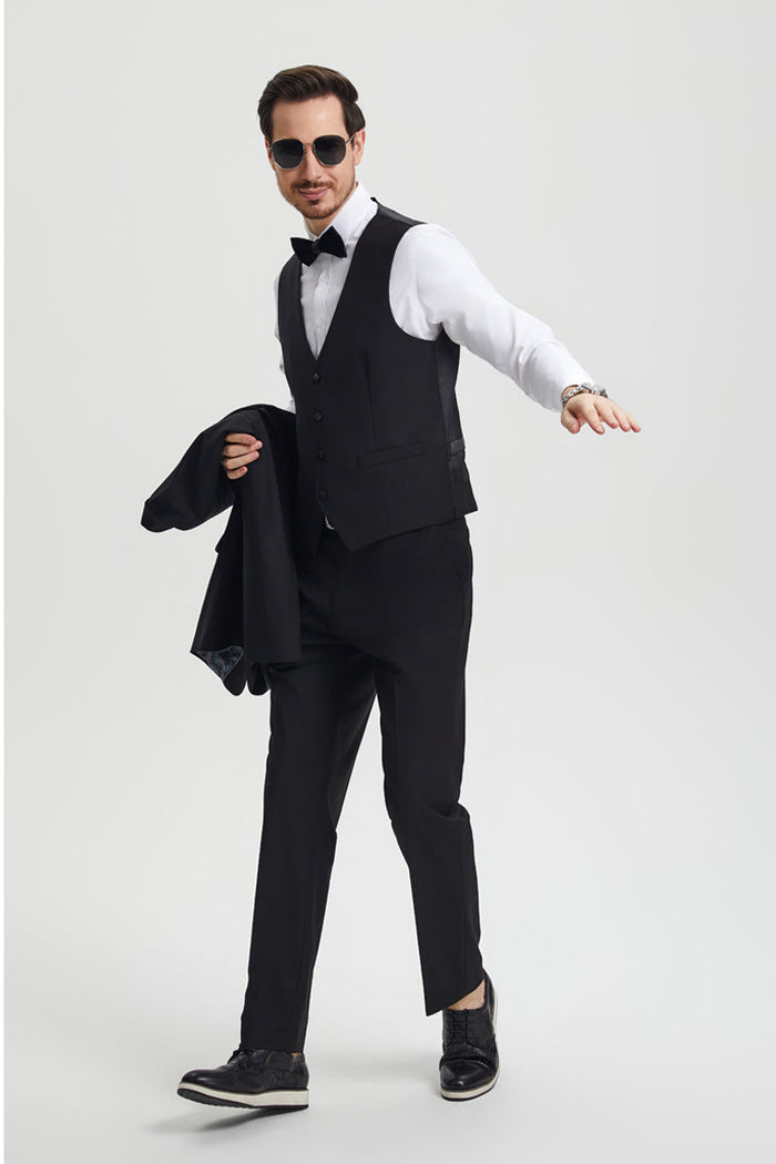Stacy Adams men's black tuxedo with a one-button closure and shawl lapel. Includes a fitted 5-button vest and full-length trousers. Crafted from sleek, solid black fabric. Features a structured vest and contrasting patterned inner lining.