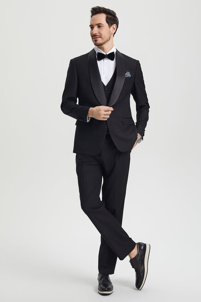 Men's black Stacy Adams one-button tuxedo. Features a tailored blazer with satin shawl lapel, matching vest and trousers. Clean lines create a streamlined look. Includes white shirt & black dress shoes.
