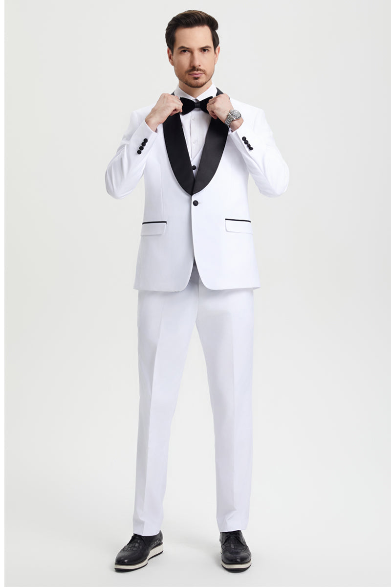 Men's white Stacy Adams tuxedo. Tailored fit, single-button closure, black shawl lapel, and matching white trousers. Features black-trimmed pockets. Worn with a bow tie and black shoes for a formal look.
