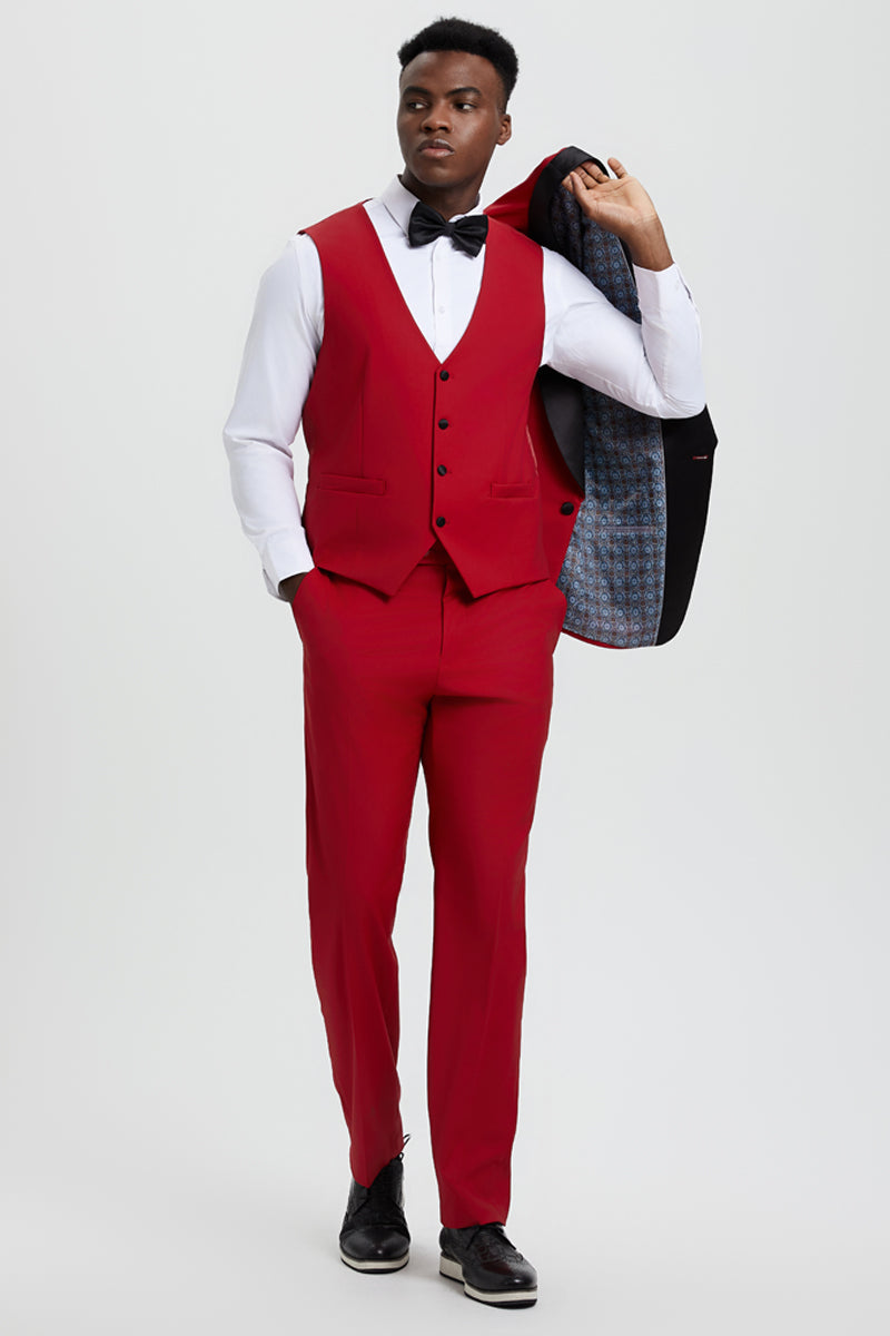 Red Stacy Adams one-button tuxedo with shawl lapel. Includes matching vest & trousers, fitted silhouette. Model wears white shirt, black shoes. Black jacket with patterned lining.
