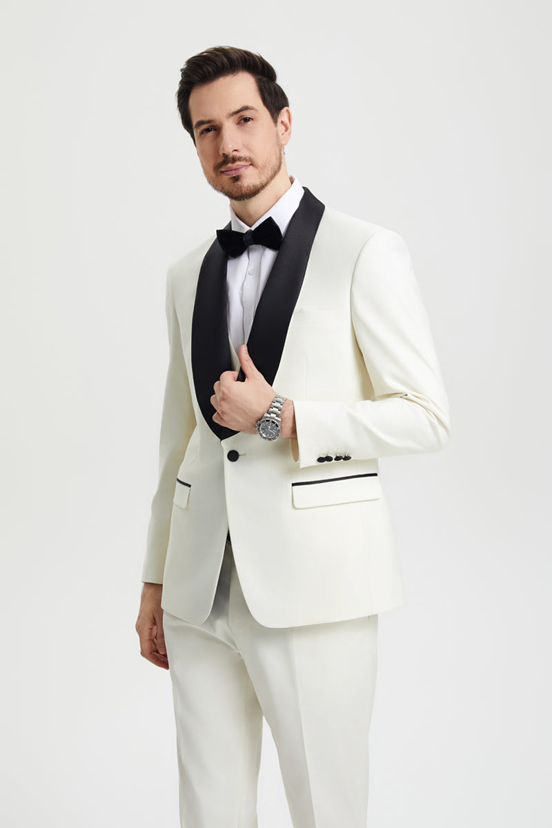 Ivory Stacy Adams men's tuxedo with black shawl lapel. One-button closure, tailored fit, and black pocket accents. Includes matching trousers for a sharp, formal look.
