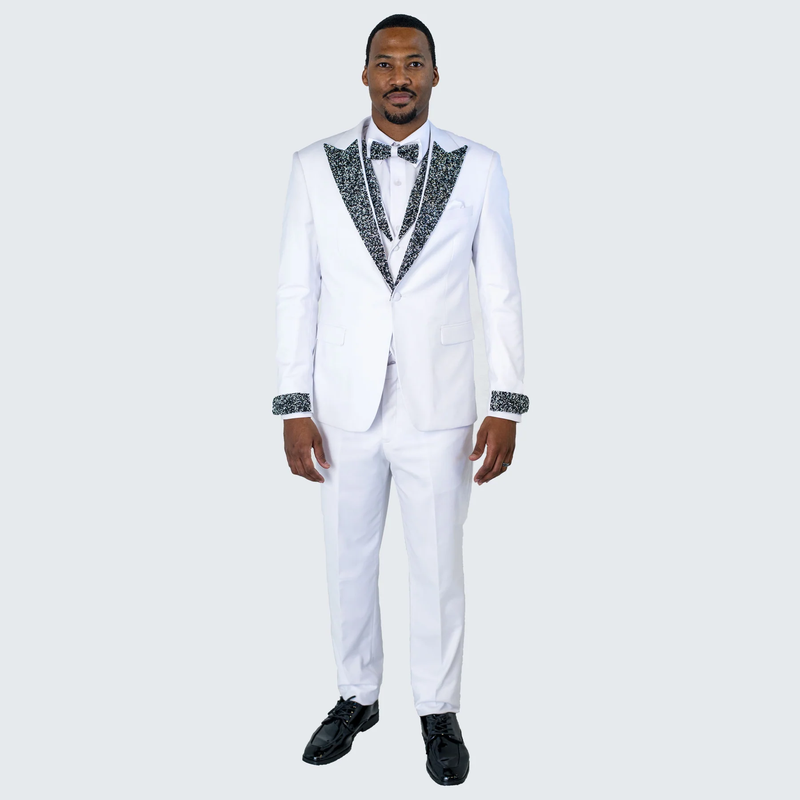Men's white tuxedo with tailored fit. Features solid white fabric, black stone-embellished lapels & cuffs, single-breasted closure, and a matching bow tie for prom or wedding.
