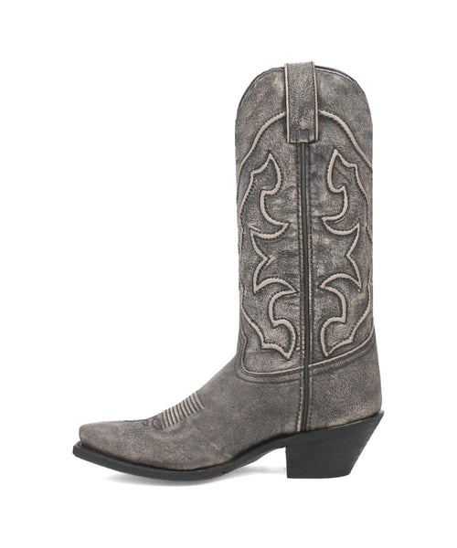 Laredo Reva women's black boot. Tall, pointed shaft with stitched design. Leather-like, textured material. Low stacked heel, rounded toe with ridges. Dark black with shade variations.
