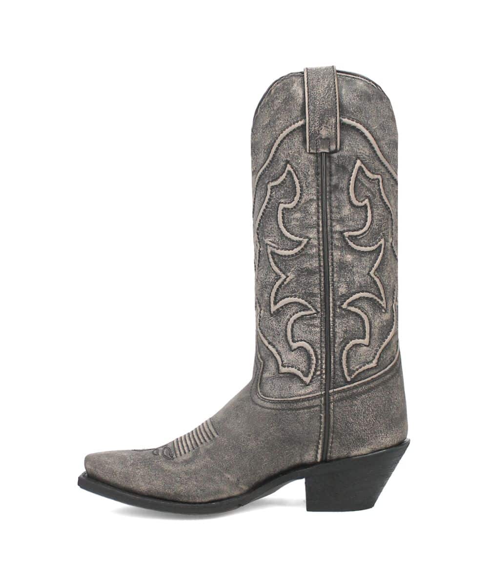 Laredo Reva women's black boot. Tall, pointed shaft with stitched design. Leather-like, textured material. Low stacked heel, rounded toe with ridges. Dark black with shade variations.

