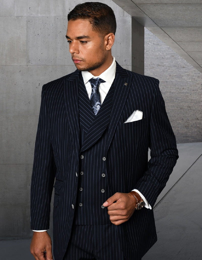 Navy pinstripe double-breasted vest suit for men. Structured silhouette with white stripes, likely wool blend. Features double-breasted front, vest, shawl lapel, and pocket square. Formal design.
