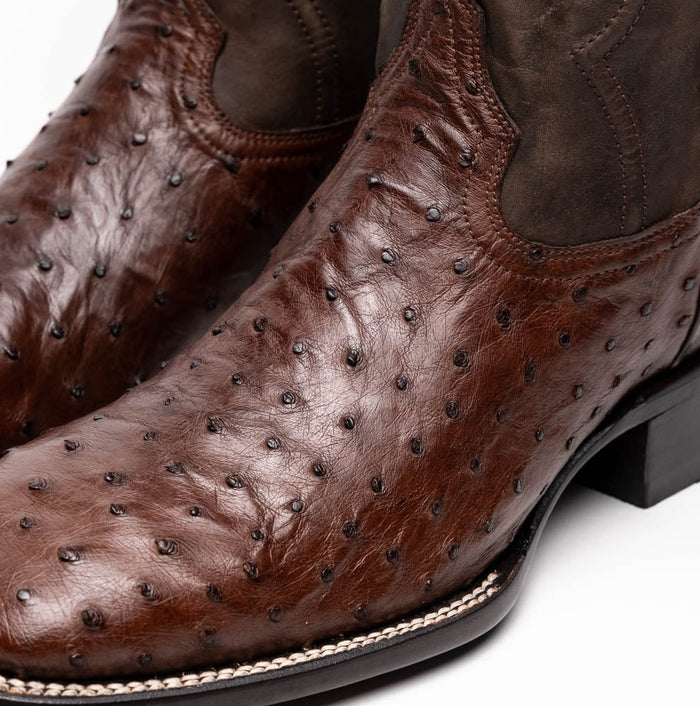 Marco Di Milano Alabama boots. Brown ostrich quill leather upper with textured bumps. Dark leather shaft. Square toe design. Subtle sole stitching.
