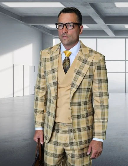 The Statement mens 3 piece plaid suit features a modern fit with wide peak lapels and is constructed from 100% wool. The suit displays a prominent plaid pattern in shades of yellow and brown. It consists of a patterned jacket, a cream-colored vest, and matching trousers.