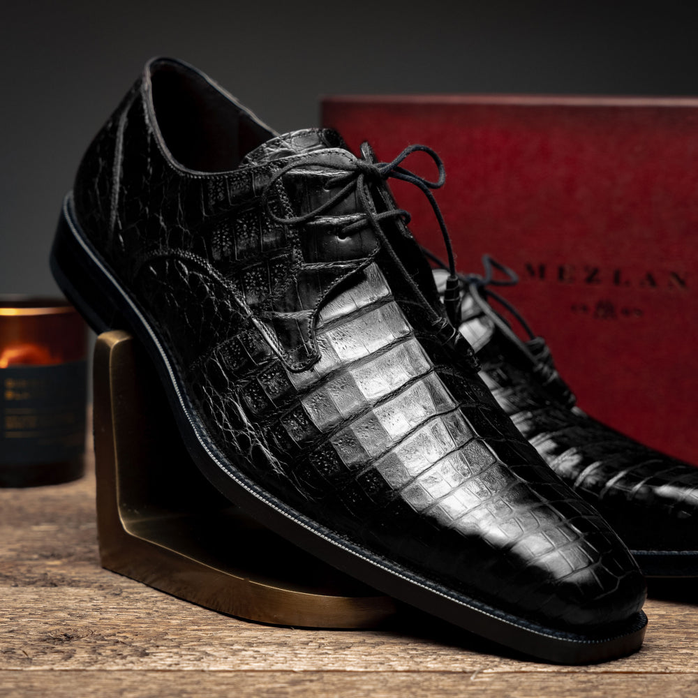 Mezlan Anderson derby shoes: Black crocodile leather with geometric textures, rounded toe, low black rubber sole. Lace-up closure. Streamlined design with heel elevation.

