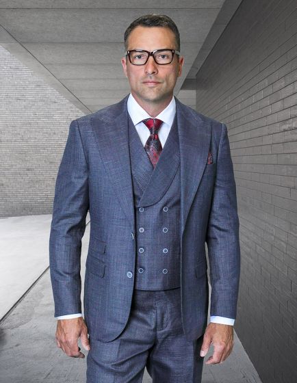 Statement mens 3 piece suit features a modern fit with a peak lapel design. The suit is composed of 100% wool in a dark blue color, displaying a subtle texture. It includes a double-breasted vest and tailored trousers, maintaining a cohesive look.