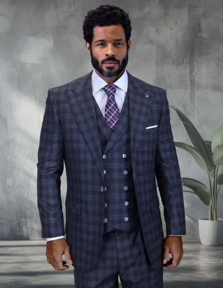 The mens 3 piece wide leg suit features a windowpane plaid pattern in dark tones of navy and gray. The jacket has a structured form with peak lapels and is tailored for a fitted look. The vest is buttoned and complements the overall ensemble, while the trousers exhibit a wide leg design.
