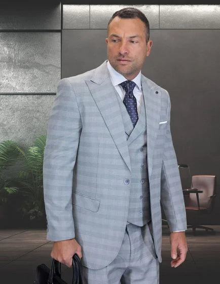 The Statement mens 3 piece big and tall suit features a light gray color with a subtle plaid pattern. The suit comprises a blazer, vest, and trousers, all tailored for a larger fit. The blazer has notched lapels, two front pockets, and a single button closure.