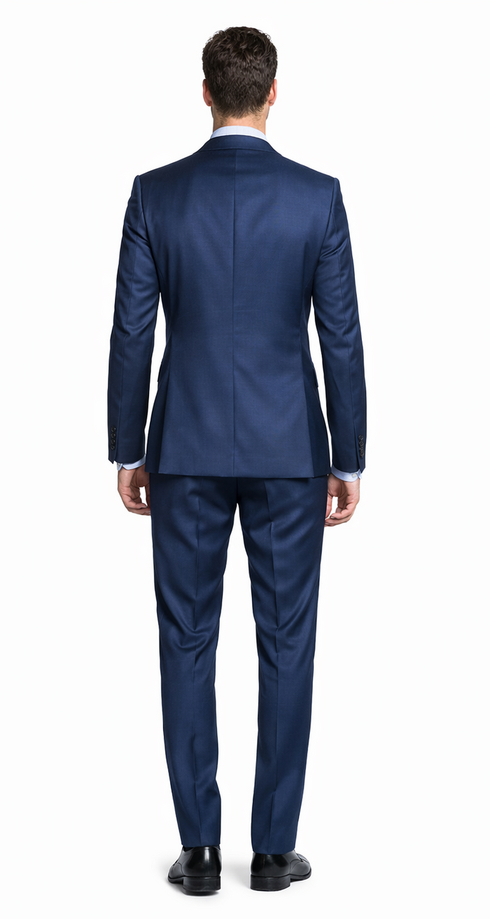 Bertolini French blue wool-silk suit: Tailored blazer with structured shoulders & streamlined trousers. Smooth, deep blue fabric with a subtle sheen. Fitted silhouette.
