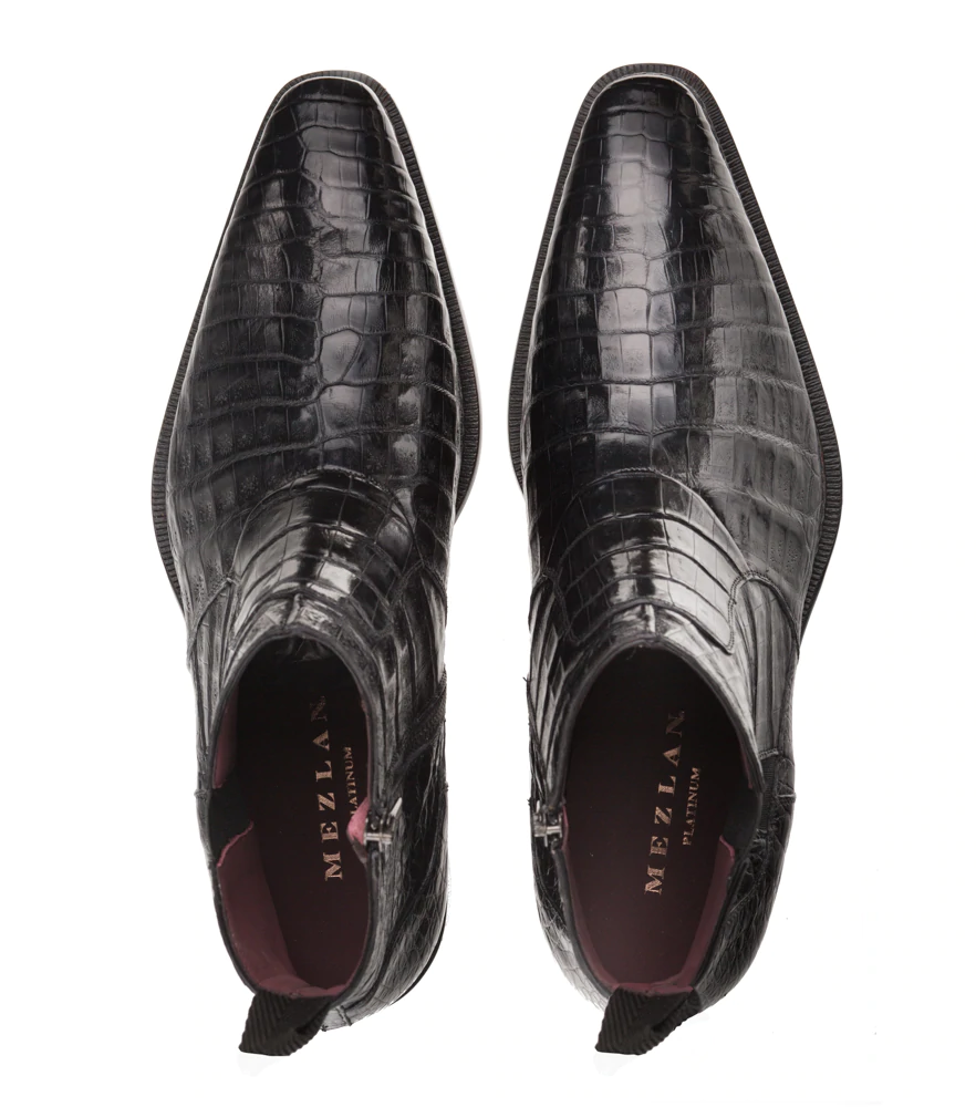 Black Mezlan Blackmore dress boots: crocodile leather, pointed toe, side zip. Glossy texture, burgundy interior, pull tab. Flat, textured sole. Sleek silhouette.
