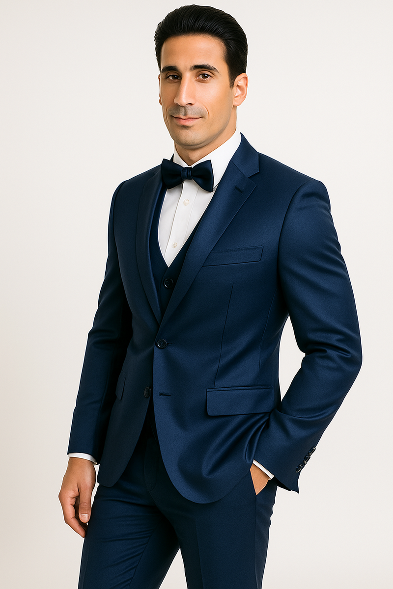 Navy blue "Majesty" tuxedo: satin-finish jacket (peak lapel, single-button), matching trousers, waistcoat, and bow tie. Smooth, polished fabric. Formal four-piece set.
