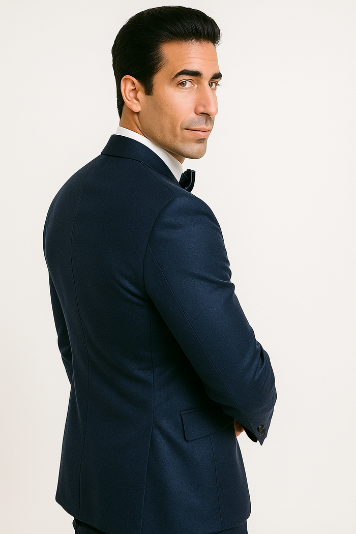 Alberto Nardoni's blue tuxedo: fitted jacket with structured shoulders, tapered waist, single-button closure, and standard lapels. Includes black bow tie. Features side pockets and contrasting lining. Deep blue hue, sophisticated design.
