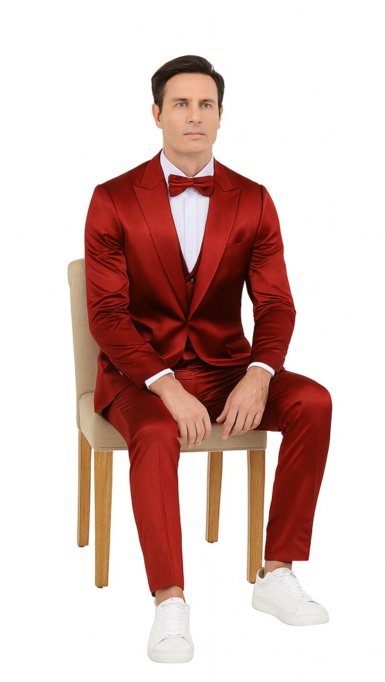 Burgundy satin Tazzio 3-piece suit: peak lapel jacket, double-breasted vest, slim trousers. Shiny satin material, sleek silhouette. Model wearing white sneakers.