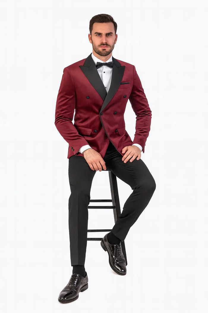 Luxurious burgundy velvet tuxedo jacket by Alberto Nardoni. Double-breasted design, black satin peak lapels, six buttons, and side pockets. Structured fit with padded shoulders.
