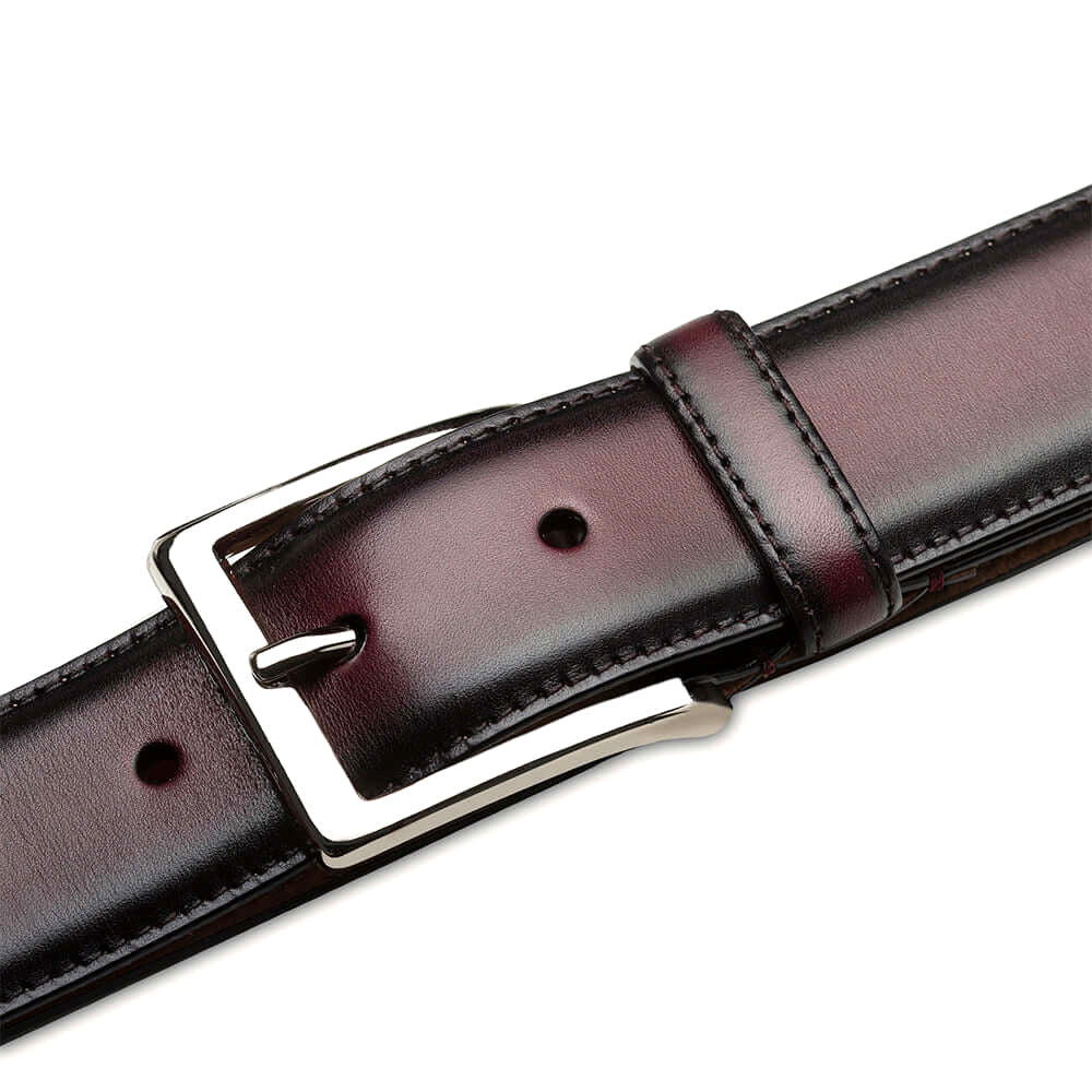 Burgundy Mezlan calfskin belt with shiny patina. Features a silver rectangular buckle and adjustable sizing. Structured, flat design with visible edge stitching. Classic and refined.
