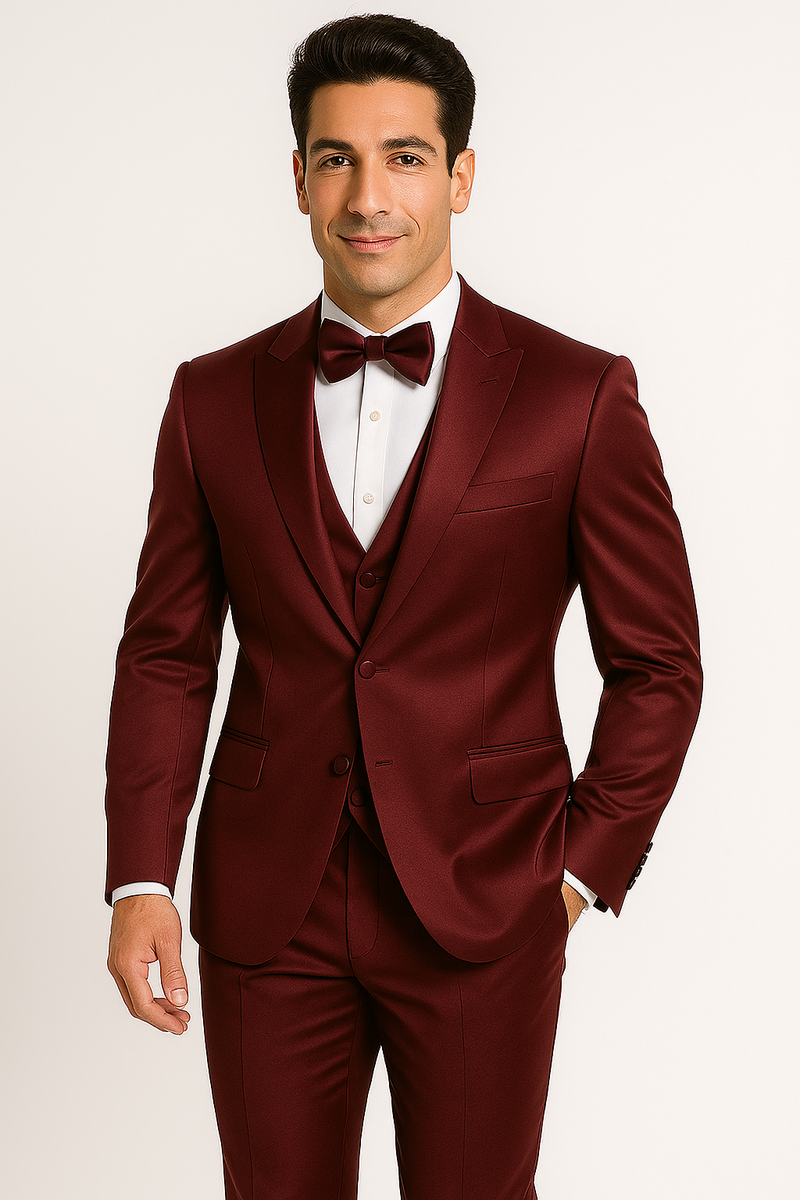 Alberto Nardoni's burgundy Majesty tuxedo: fitted jacket with notched lapel, white shirt, matching vest, and trousers. Smooth, glossy fabric. Tailored for form. Includes bow tie.
