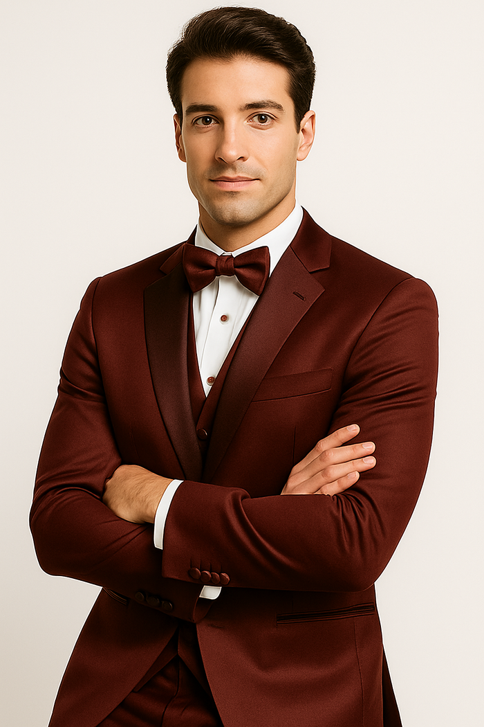 Burgundy Majesty tuxedo by Alberto Nardoni: fitted jacket with satin lapel, matching vest & pants. Includes white shirt & burgundy bow tie. Smooth, glossy fabric with button details. 4-piece set.