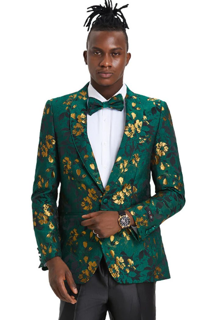 Hunter green slim fit tuxedo jacket with gold paisley floral pattern. Peak lapel, single-button closure, and buttoned cuffs. Shiny, textured fabric. Modern, bold design for formal events.
