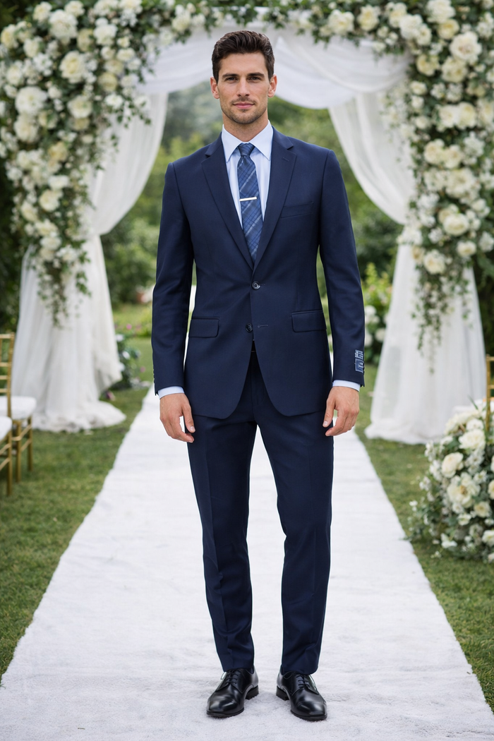 Carlo Lusso French blue suit by Albertonardoni. Structured fit, notched lapel, single vent. Deep blue, smooth fabric. Tailored trousers with crease. Paired with light blue shirt and blue patterned tie.
