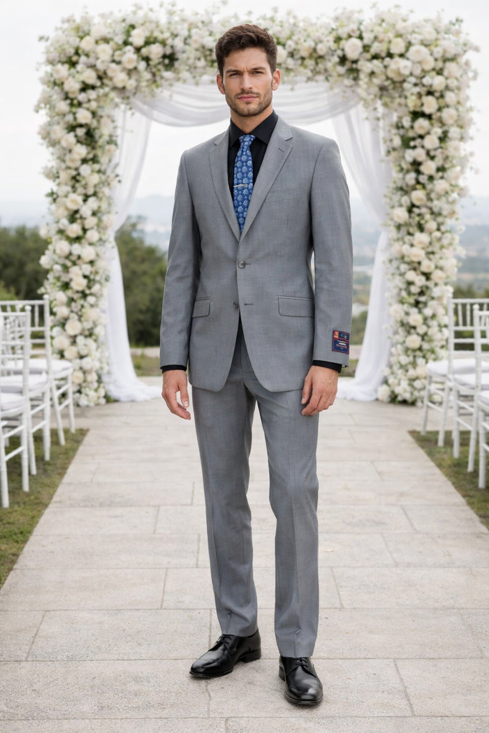 Carlo Lusso slim-fit gray poly-blend suit by Albertonardoni. Two-button jacket with notched lapel, pocket square. Straight-cut pants. Worn with black shirt, patterned blue tie in an outdoor setting.
