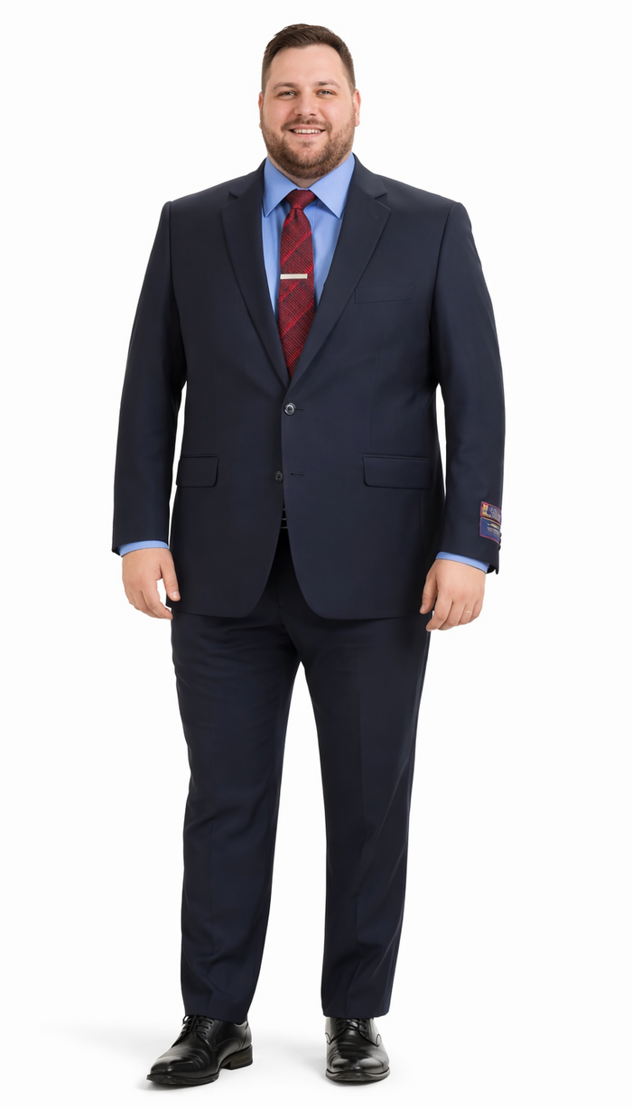 Navy Carlo Lusso suit by Albertonardoni. Tailored fit, poly blend, two-button, notched lapel. Straight-leg trousers. Contrasting blue lining visible at cuffs. Worn with a red patterned tie and light blue shirt.
