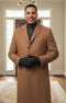 Men's light brown single-breasted topcoat with a smooth, structured form. Buttoned front, breast pocket, classic collar, and tapered sleeves. Crafted from soft, textured material.
