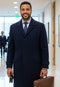 Men's navy topcoat. Single-breasted, full-length with a tailored fit & straight silhouette. Features a notched collar, two front pockets, and solid navy fabric.

