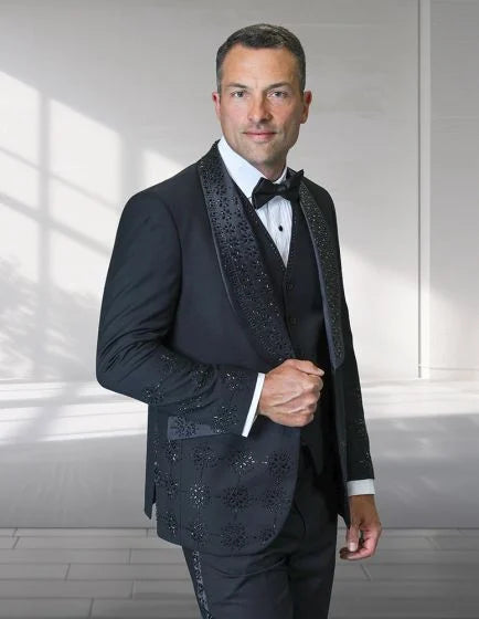 The Statement men's 3-piece modern fit tuxedo features a black fabric with embellished rhinestones on the lapels and down the front. The tuxedo includes a fitted jacket, a vest, and trousers, all showcasing a smooth texture.