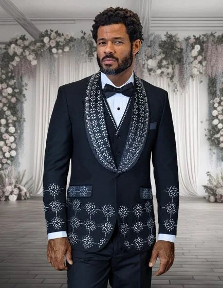 The Statement mens 3 piece modern fit tuxedo features a black fabric base with embellished rhinestones arranged in a structured pattern. The jacket has a shawl collar adorned with rhinestones, while the sides and lower front are similarly embellished.