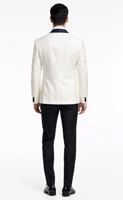 White tuxedo jacket with navy satin lapel, tailored fit, and subtle pattern. Paired with black trousers for a formal, modern look.
