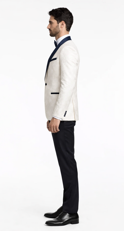 Modern white tuxedo: tailored fit, white textured jacket with navy satin lapels, navy trousers. Includes a black bow tie. Elegant and stylish.
