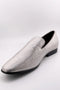 Sharkskin silver tuxedo shoes: sleek, pointed toe, low-cut design. Textured silver upper with fine lines. Black sole, slip-on style, streamlined silhouette for a modern look.
