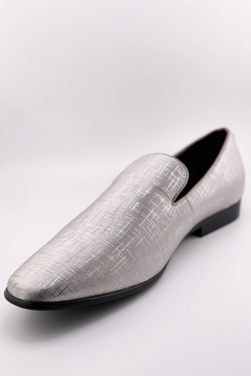 Sharkskin silver tuxedo shoes: sleek, pointed toe, low-cut design. Textured silver upper with fine lines. Black sole, slip-on style, streamlined silhouette for a modern look.
