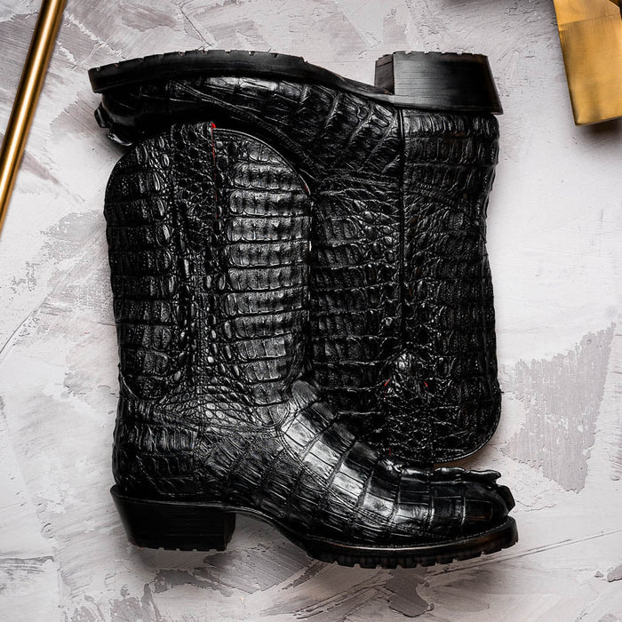 Marco Di Milano Marlboro Black cowboy boots. Tall shaft, hornback crocodile tail texture, pointed toe. Tractor sole for rugged look, block heel. Structured design with detailed stitching.
