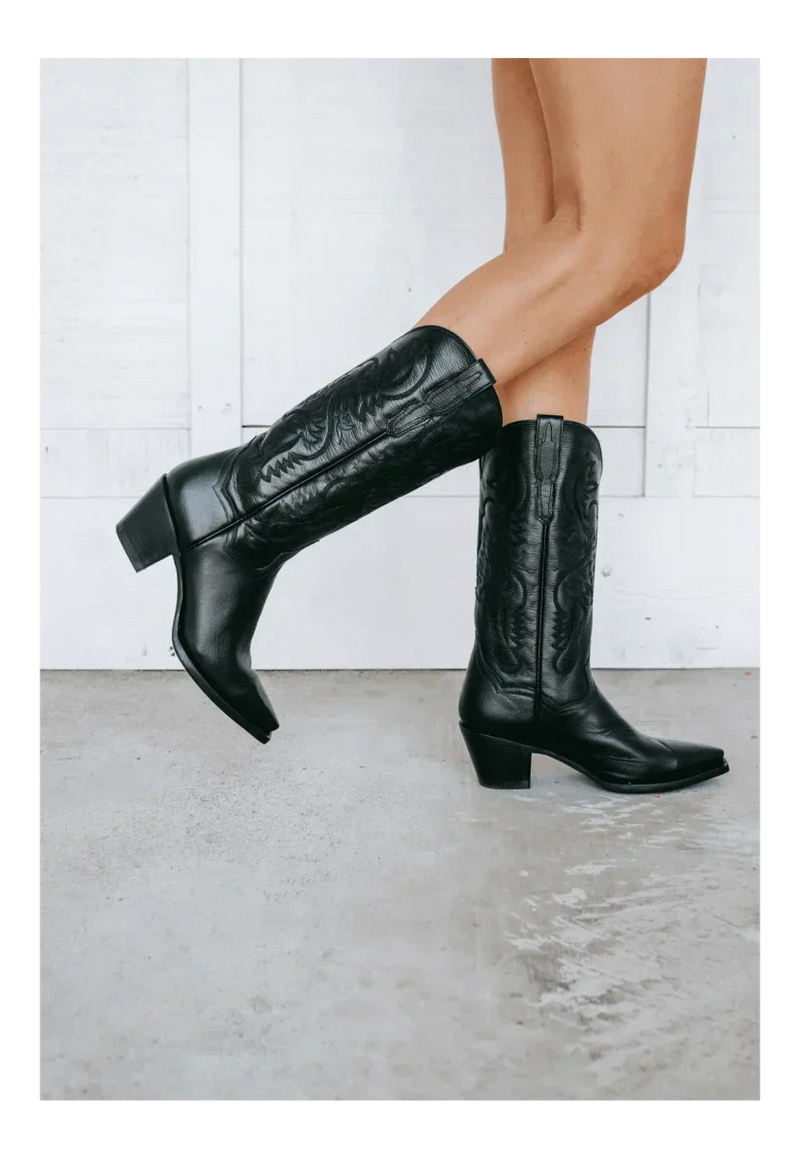 Dan Post Maria boots: black leather, snip toe, tall shaft with stitching, stacked heel. Sleek design with a slight top curvature.

