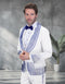 The Statement mens 2 piece modern fit tuxedo is primarily white and features rhinestone detailing in blue. The jacket has a structured shape with a peak lapel, adorned with scattered rhinestones along the collar and pockets, while the trousers are plain white.