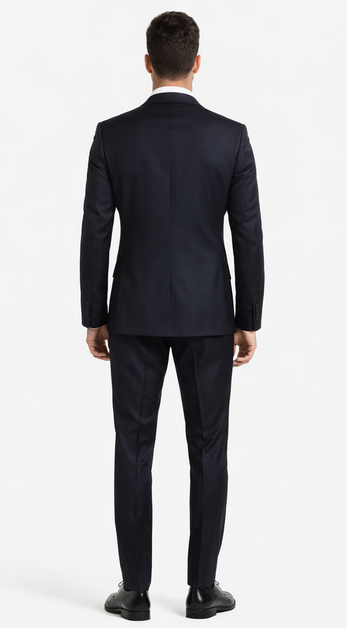 Italian black wool suit with a fitted silhouette. Jacket: single rear vent, two side pockets. Trousers: tailored, tapering fit.
