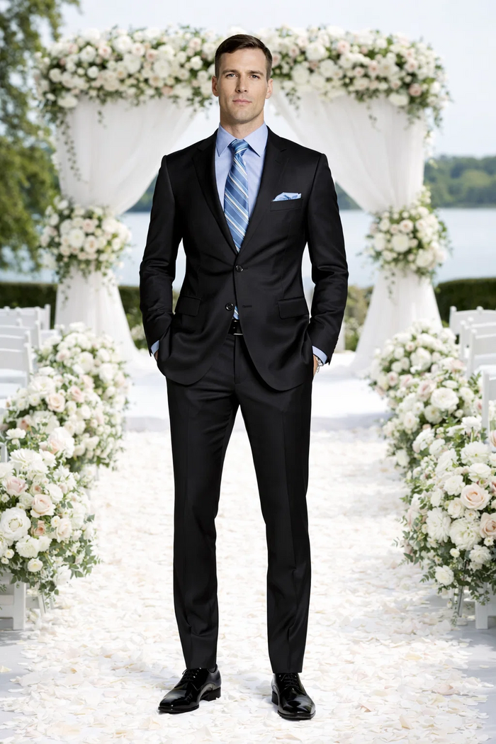 Giorgio Fiorelli black suit with French blue shirt. Tailored black jacket with notch lapels, matching trousers. Light blue shirt, striped tie, pocket square. Fitted, modern silhouette.
