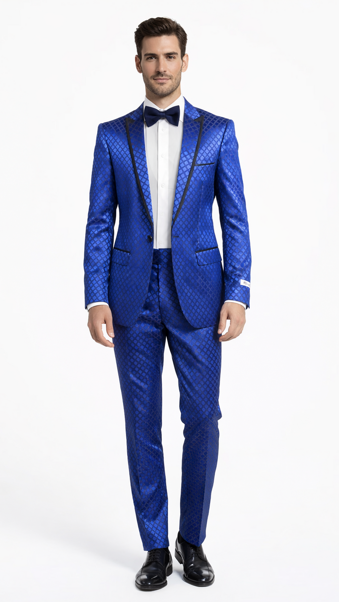 Navy checkered slim-fit tuxedo by Albertonardoni. Features a glossy fabric with black satin trim, peak lapel, and structured shoulders. Includes matching tailored trousers. Worn with a white shirt and bow tie.
