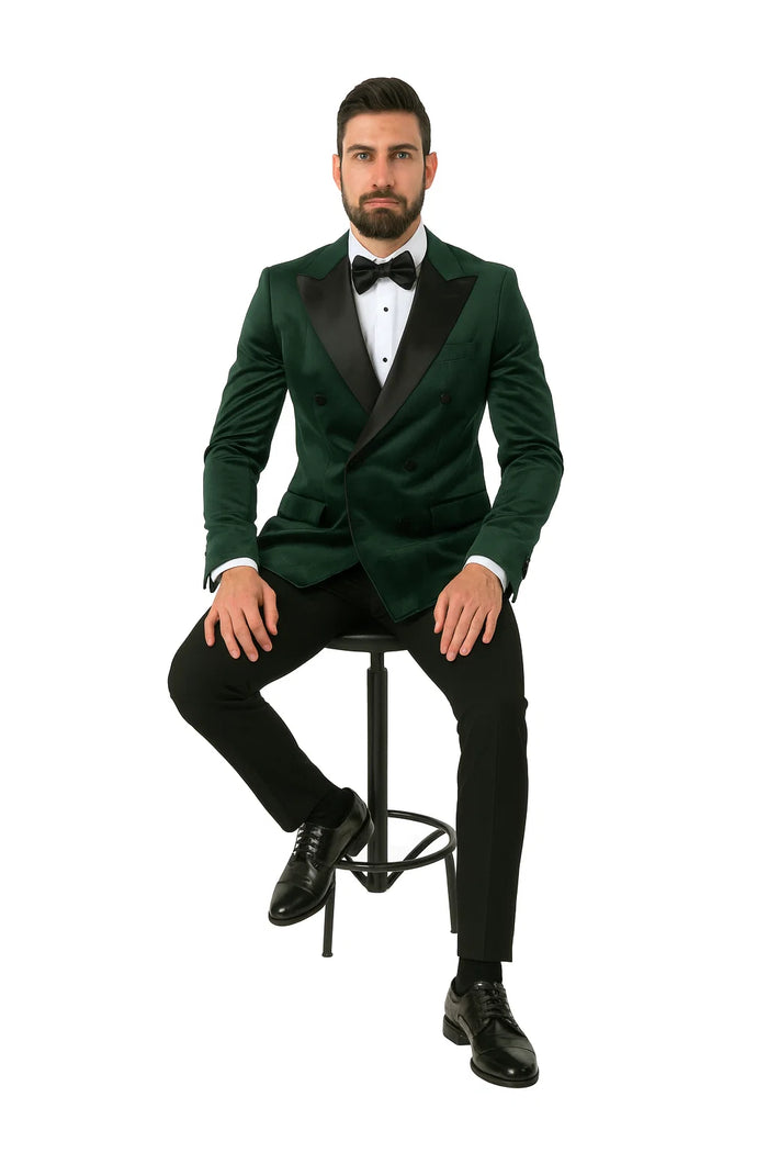 Green velvet double-breasted tuxedo jacket. Rich green hue, soft fabric. Black satin lapels, front buttons. Two pockets, tailored for a structured silhouette.
