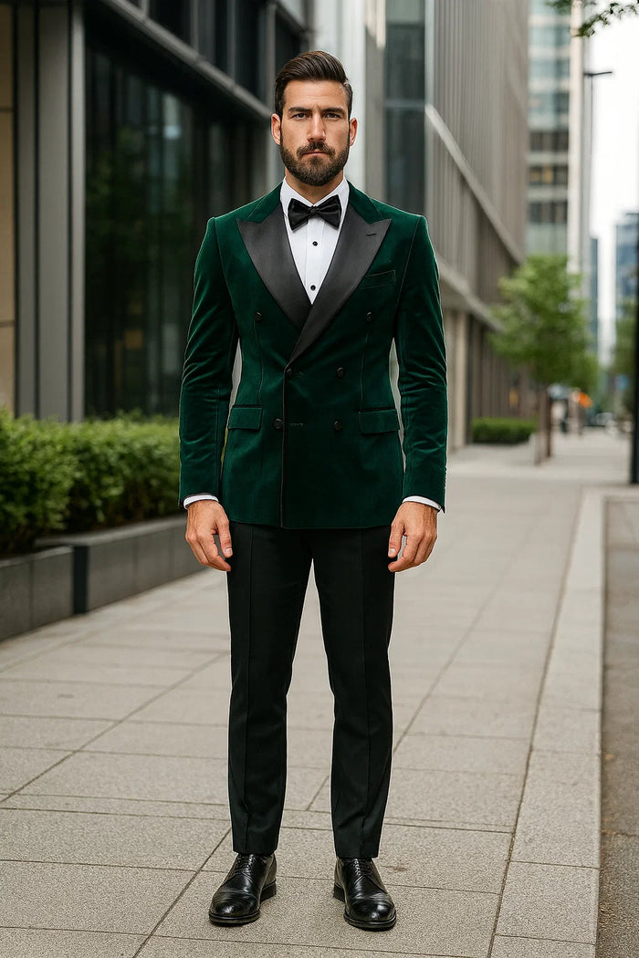 Green velvet double-breasted tuxedo jacket with peak lapels, tailored fit. Rich green color, soft texture. Paired with white shirt, black bow tie, tailored black trousers, and leather shoes.
