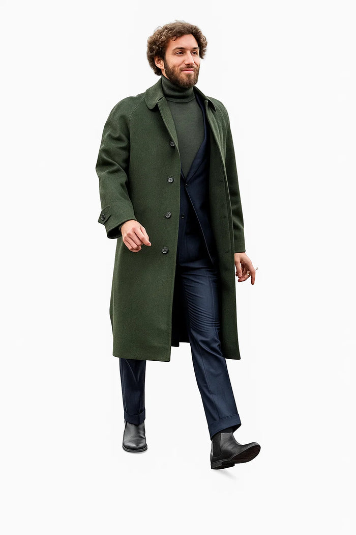 Olive green wool overcoat with shawl collar, black buttons, & straight silhouette. Paired with dark turtleneck, navy trousers. Winter business casual outfit in olive, navy, & black.
