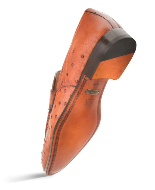 Mezlan's Lisbon brandy slip-on: Textured reddish-brown ostrich leather, elongated shape, rounded toe, dark wooden heel. Decorative stitching, smooth sole.
