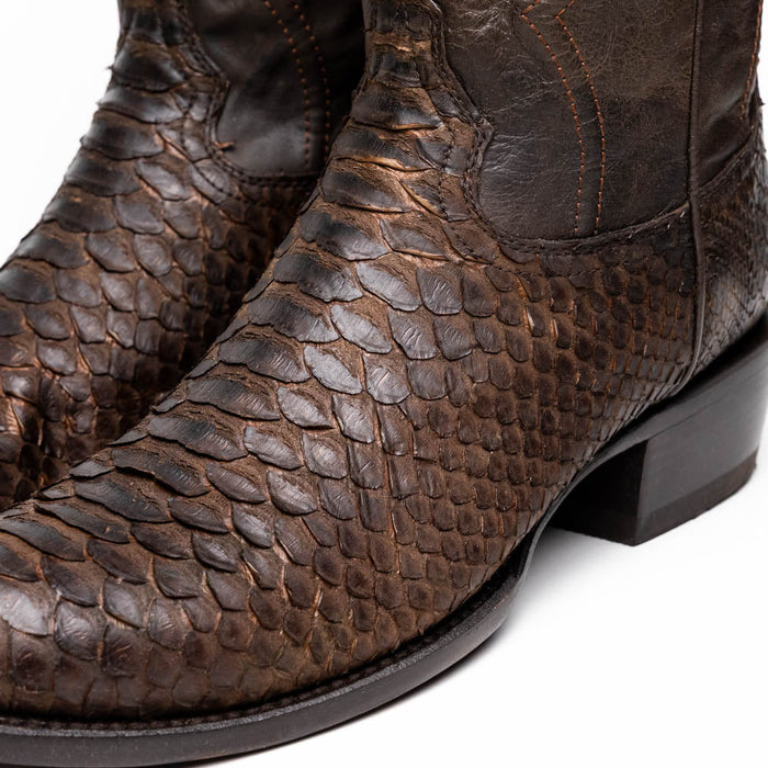 Brown python cowboy boots by Marco Di Milano. Round toe, textured reptilian scales. Contrasting brown stitching, structured heel. Distinctive and stylish.
