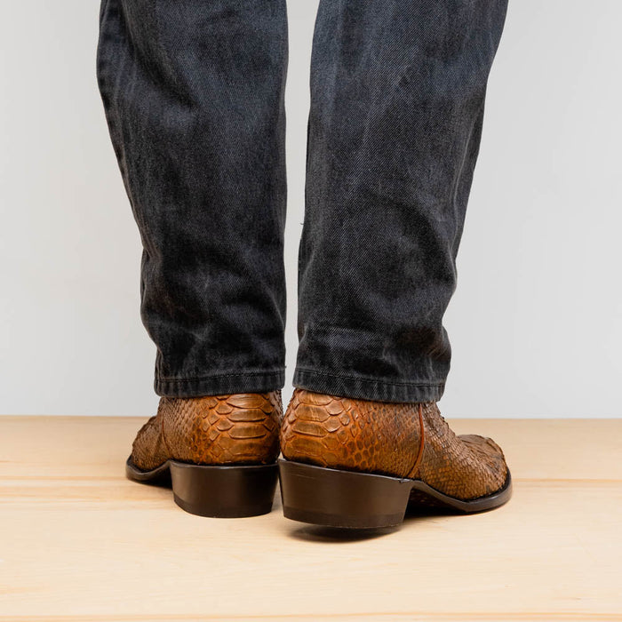 Marco Di Milano Kansas Cognac cowboy boots. Brown, textured leather upper with a scale-like pattern. Rounded toe, low stacked heel, and smooth stitching.
