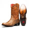 Marco Di Milano Kansas cognac cowboy boots in tan leather. Round toe, scale-like texture, decorative stitching, and red lining. Branded sole with tread design.
