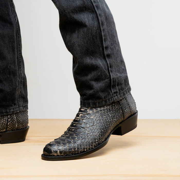 Black leather cowboy boots with reptile texture. Round toe, mid-calf height, leather heel, smooth sole. Side panels for easy wear.
